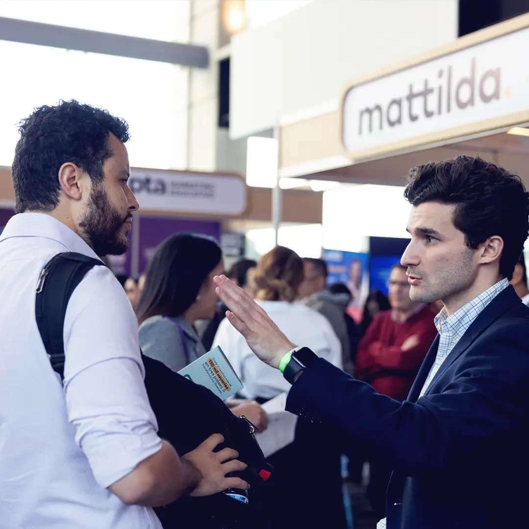 Representante explicando su oferta educativa en stand de patrocinador