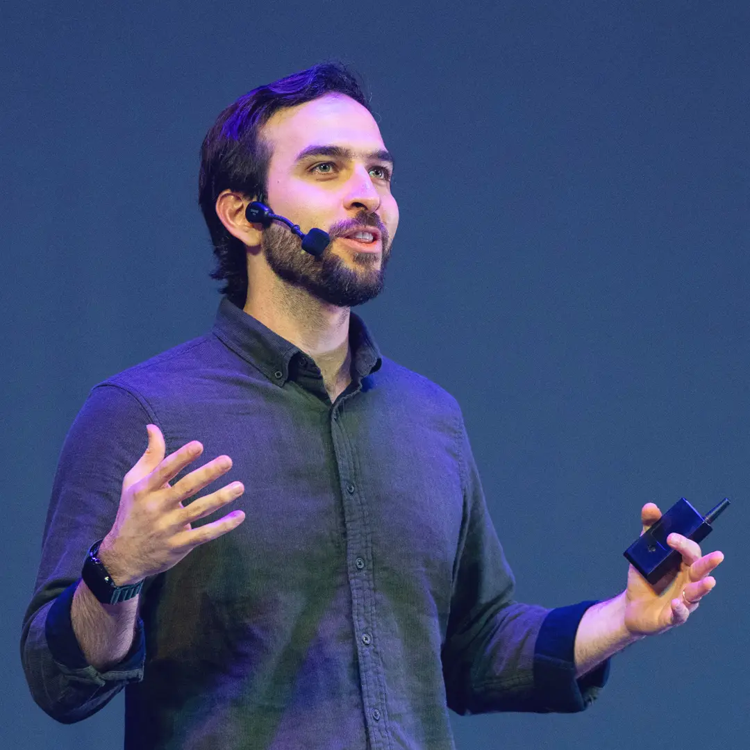 Ponente con micrófono inalámbrico exponiendo en escenario principal