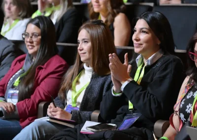 Asistentes atendiendo con entusiasmo una conferencia y tomando notas en CIMEDU.